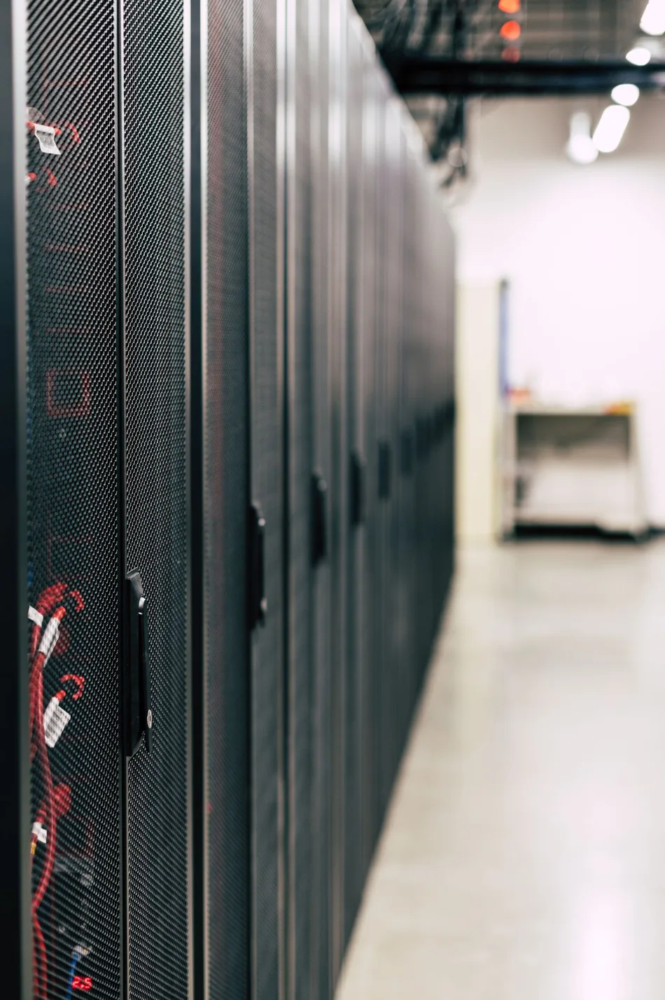 Photograph of server cabinets and cabling along a data-centre aisle